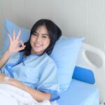 A smiling patient in a hospital bed.